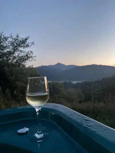 Pahar de vin la apus pe marginea jacuzzi-ului